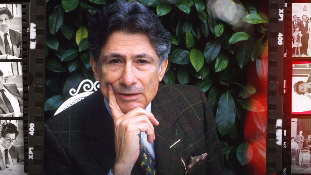 Edward-said-between-worlds_nyff64_01jpeg | the Cinema Group a Middle-aged Man in a Plaid Blazer Sits Outdoors, Hand on His Chin, with Green Leaves Behind and a Film-strip Border on the Sides.