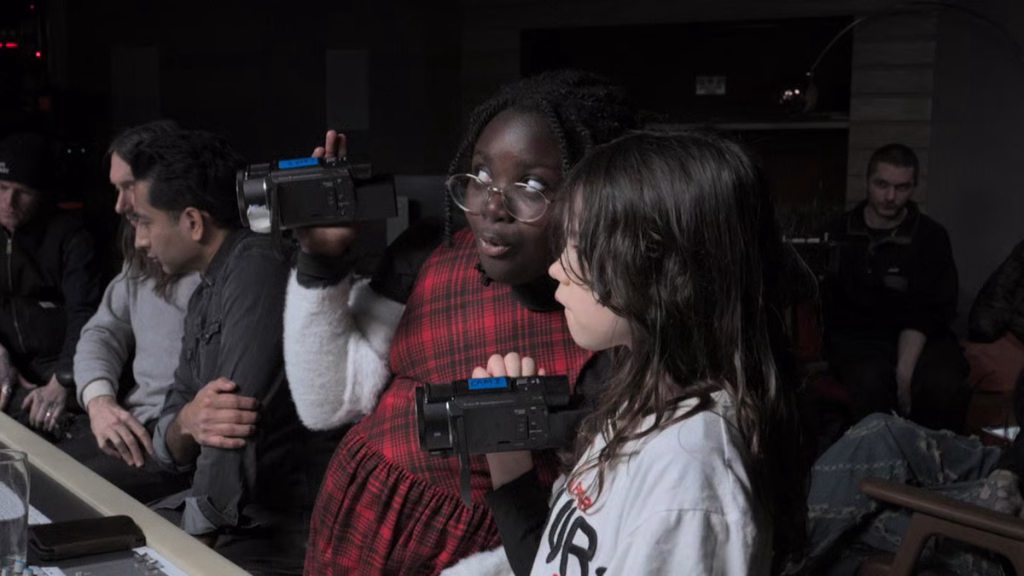 Joy-of-joys_nyff64_1jpg | the Cinema Group Two Young Girls Hold Handheld Video Cameras and Chat During a Group Workshop in a Dim Room.