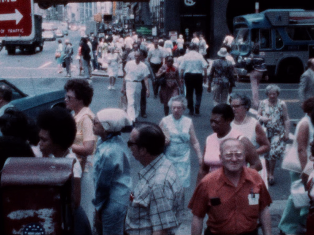 Suicide-note_nyff64_02-2jpg | the Cinema Group Busy City Street Filled with Pedestrians Walking Toward the Camera; a Bus and Red Traffic Sign Visible in the Background.